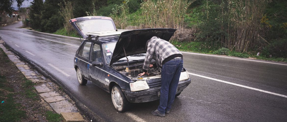 Tabarka'da, yağmurlu bir yolda bir bireyin acil yol kenarı araç bakımı yaptığı an.